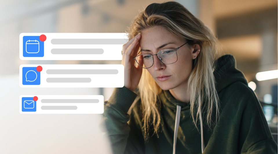 A freelancer with her head in her hand, overwhelmed by calendar, chat and email notifications piling up on screen.